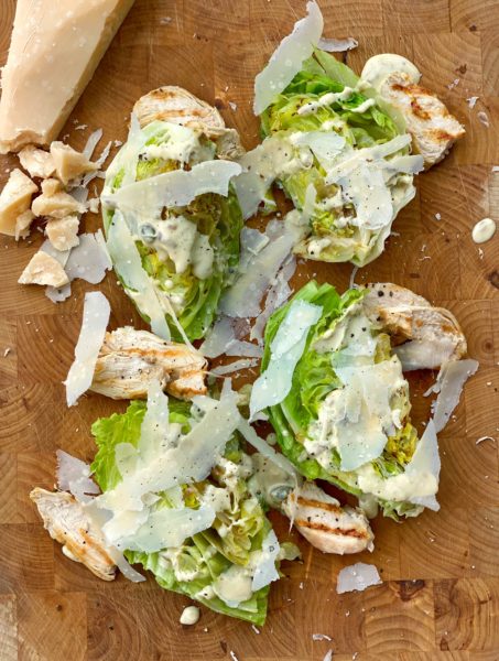 Grillierter Caesar Salad auf Holzbrett mit Parmesan 