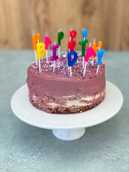 Violette Geburtstagstorte mit Buchstaben-Kerzen